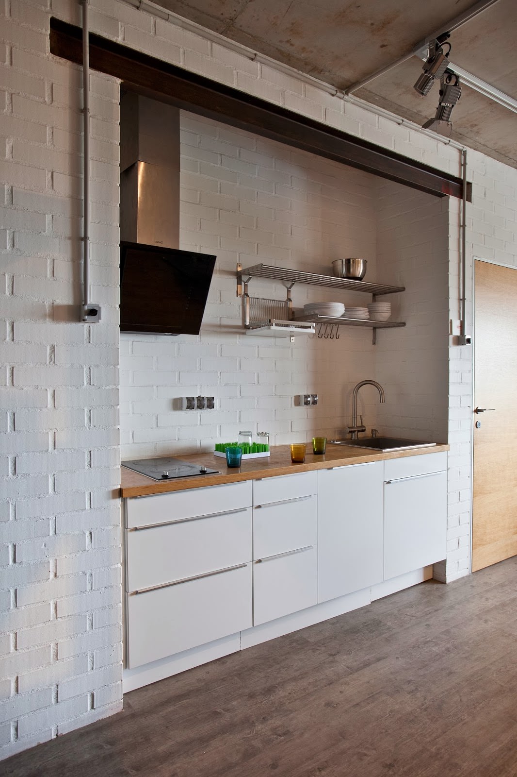 кухня с белыми кирпичными стенами в интерьере креативной квартиры