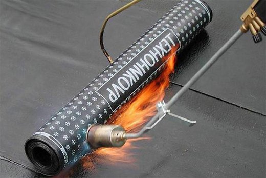 Для гидроизоляции пола нагреваем материал горелкой