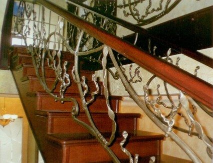 Деревянные поручни на кованой лестнице