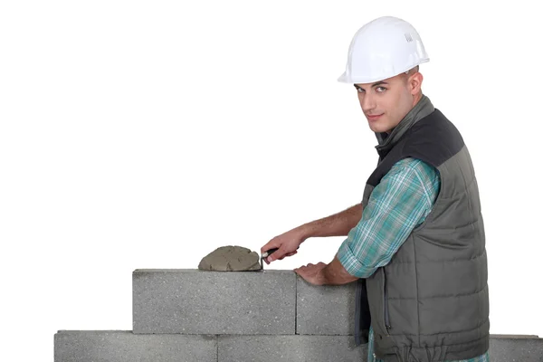 Человек, распространяя цемента на стене — стоковое фото