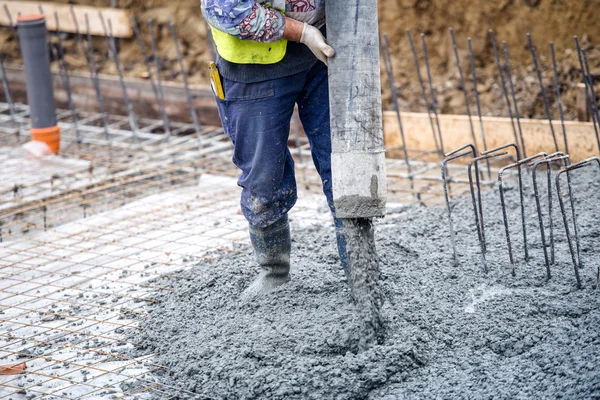 Строительство строительство работник заливки цемента или бетона с насоса трубки — стоковое фото
