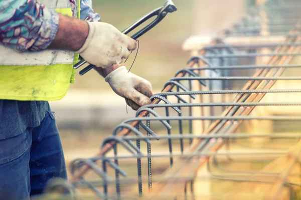 Рабочие руки с помощью стальной проволоки и кусачки безопасный баров на строительной площадке и подготовке конкретных заливки — стоковое фото