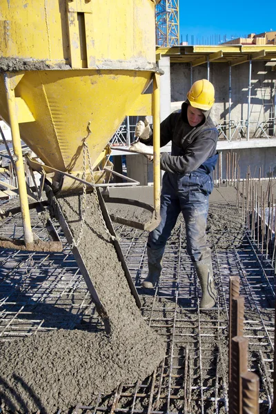 Работник строитель во время бетоном работ на строительной площадке — стоковое фото